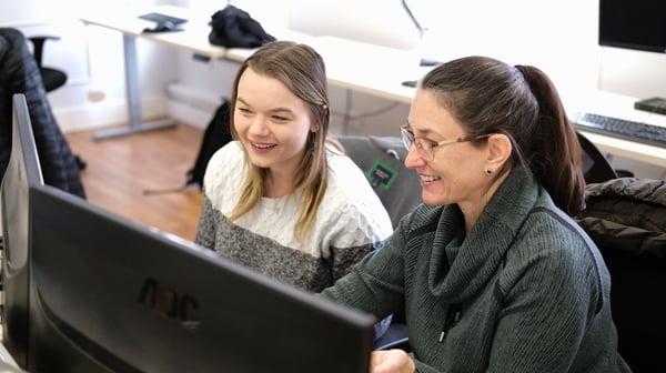 Imagen de dos personas frente a un computador