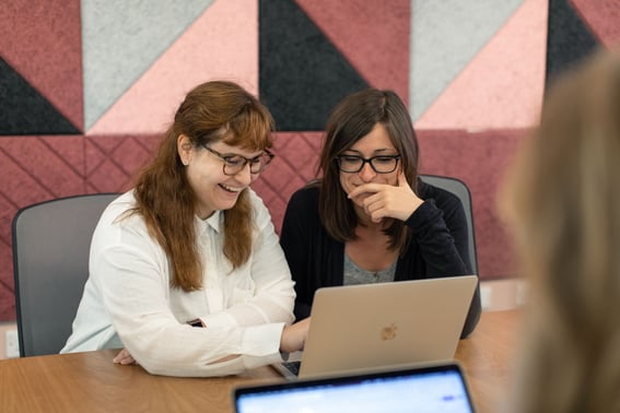 Dos mujeres trabajando frente a una computadora.