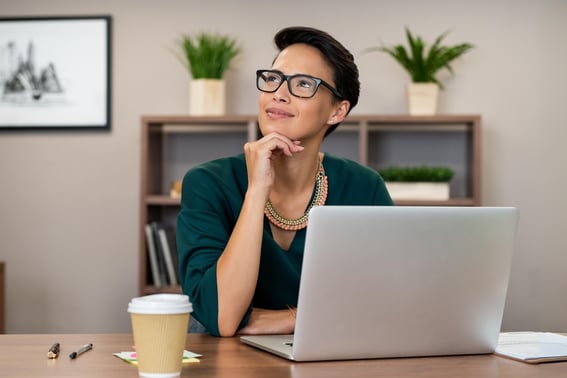 woman on laptop thinking about which crm is better for her business